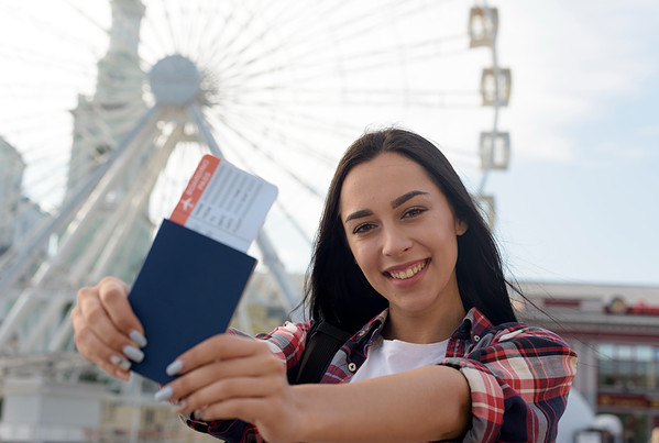 portrait smiling woman showing air ticket passport