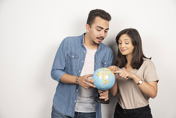 man woman posing with globe white