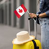cropped woman traveller holding flag canada going abroad